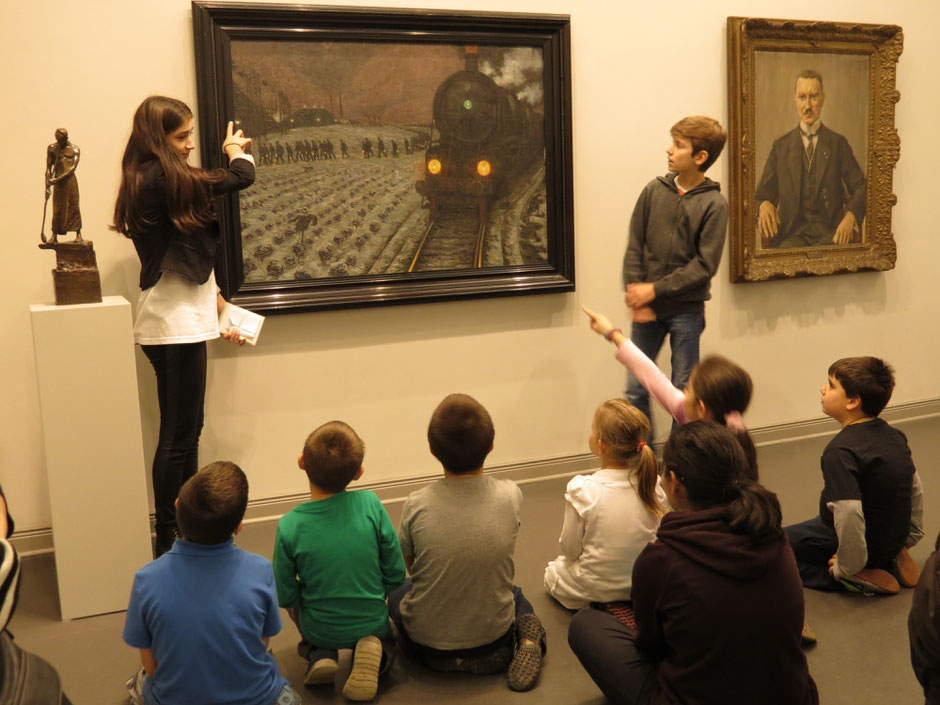 Zwei peer-Teamer und zwei Kinder sprechen über die Themen einer Ausstellung zur Stadtgeschichte.  