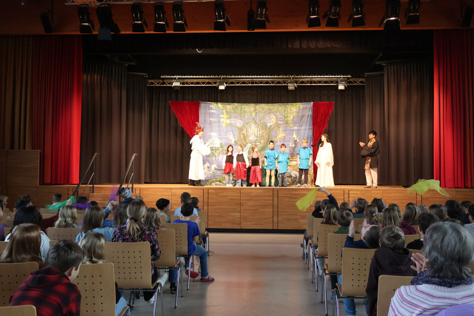 Die Operndarsteller und unsere mitwirkenden Schülerinnen und Schüler aus Stufe 3 und 4 beim großen Finale auf der Bühne