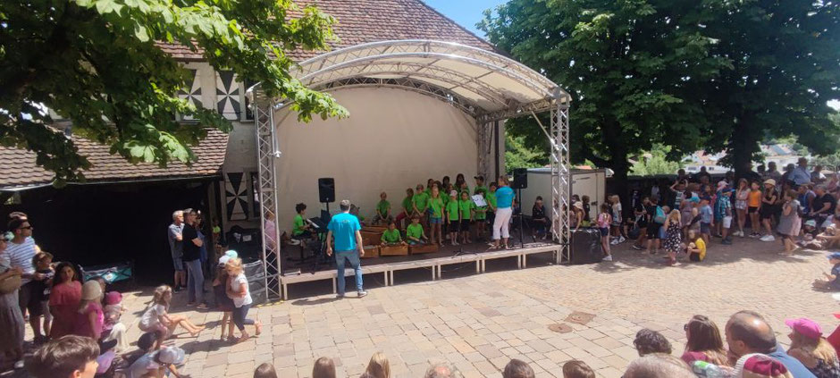 Das Schulorchester und die Chor-AG auf der Bühne hinter dem Rathaus