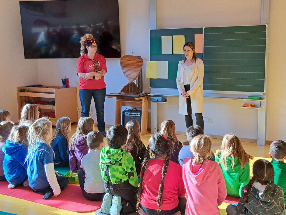 Jenny Schnetzler und Luisa Frütsche überreichen den Kindern die Heftle.