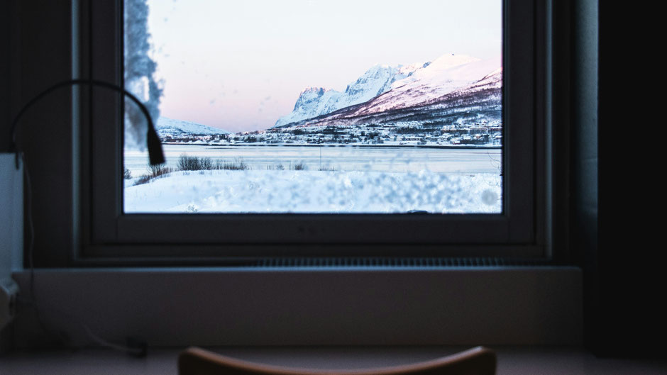 Blick aus dem Fenster auf Schneelandschaft. Bild von Angela Compagnoneauf Unsplash.