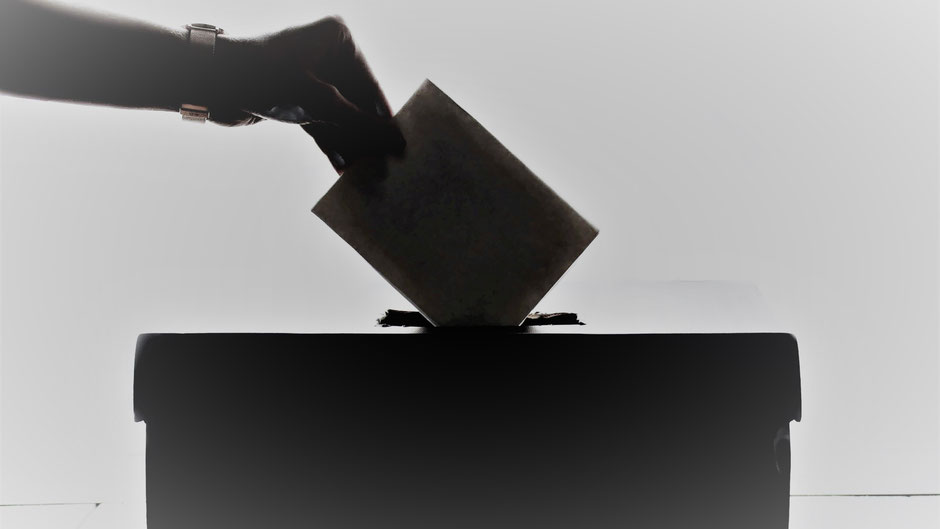 Hand wirft Wahlzettel in Urne ein. Bild von Element5 Digital auf Unsplash..