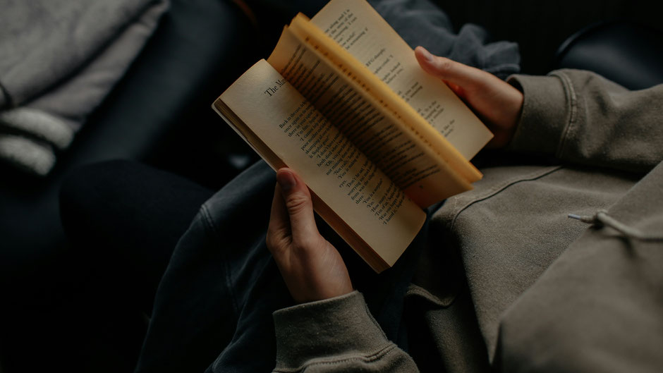 Person mit Buch. Bild von Lilly Rum auf Unsplash.
