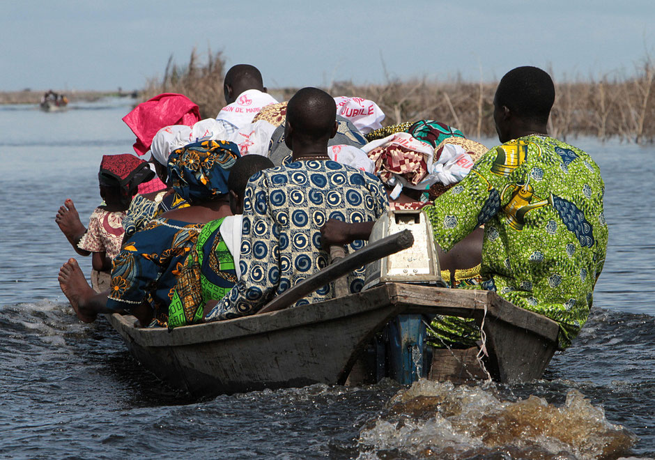 African transporting equipment on a boat. Lake Nokoue. Ganvie.