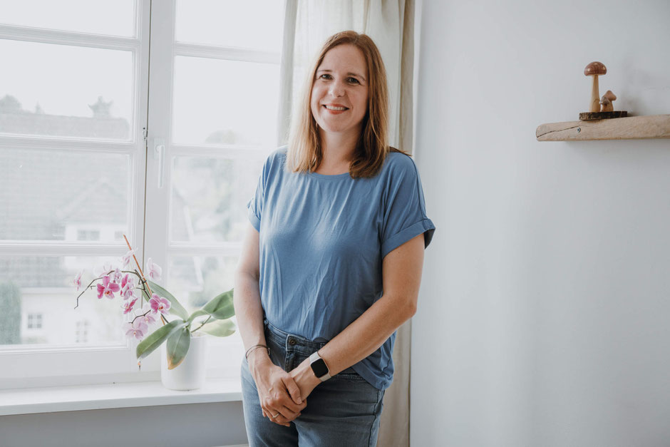Hypnosecoach Christina in ihrer Praxis - Ganzkörper Portrait vor dem Fenster