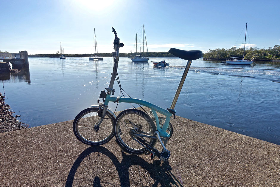 vélo bromption bleu sur un port de mer