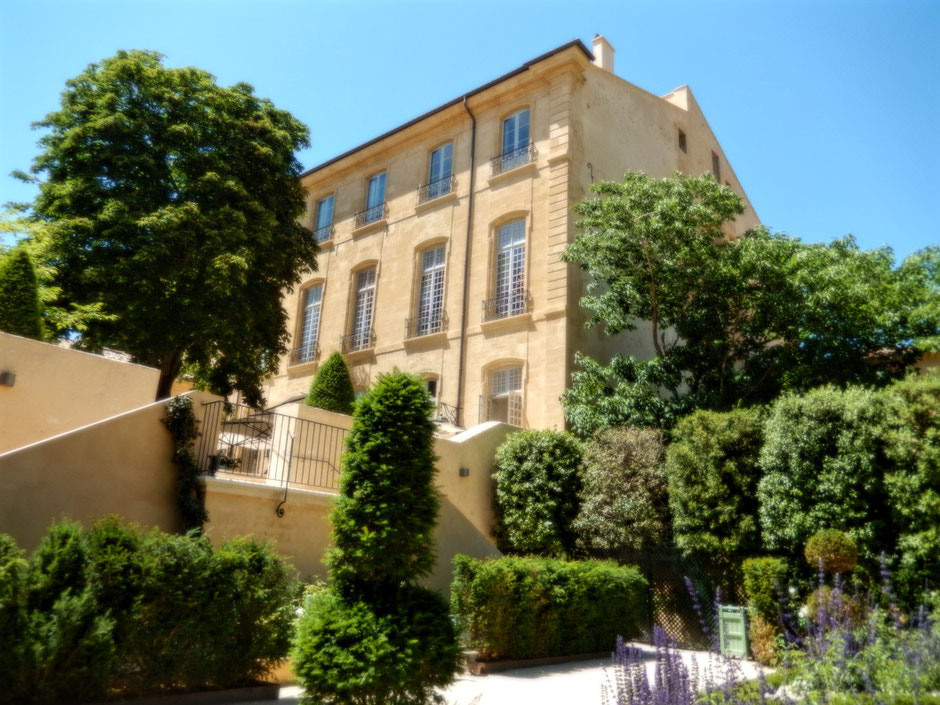 Façade ocre, côté jardin, en pierres de Rognes de l'Hôtel particulier de Caumont dans le quartier Mazarin d'Aix-en-Provence, avec un magnifique tilleul en fleurs.
