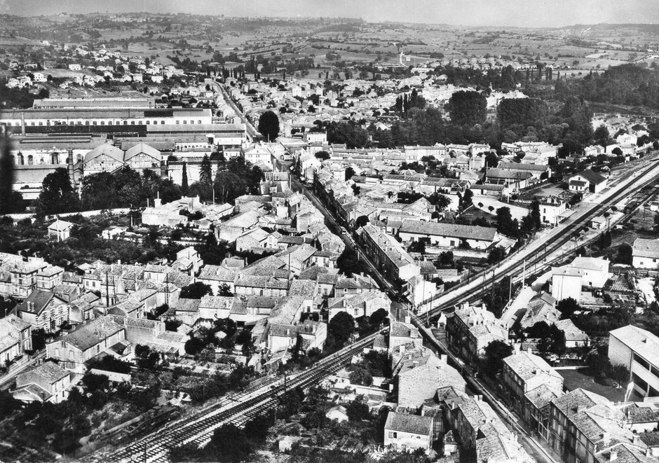 Carte postale du milieu des années 1950 - Cette vue aérienne montre bien les installations ferroviaires coupées par la route de Limoges ; en grossissant la zone du passage à niveau on arrive à distinguer les barrières oscillantes levées.