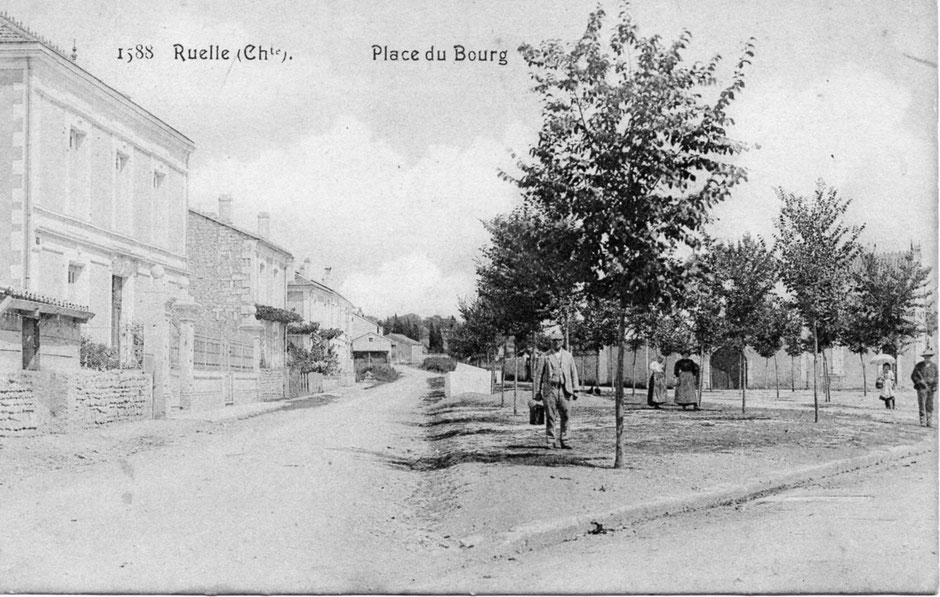 Le champ de foire des porcs. Derrière les arbres, le bâtiment avec le porche est le presbytère (de 1846 à 1907) ; après avoir servi pour loger des instituteurs, des réfugiés… il est vendu en 1923.