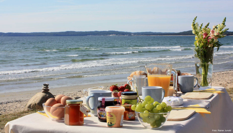 Das Bild zeigt einen gedeckten Frühstückstisch am Ostseestrand auf Rügen.