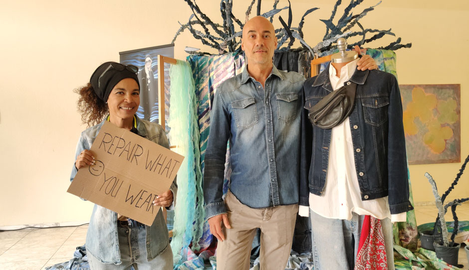 REPAIR WHAT YOU WEAR: Tam Herring, JEANS HEALER und Maßschneiderin mit Jeansliebhaber bei DENIM FOR LIFE vor der Kunstinstallation von Patrizia Zewe. Foto: Beatrix van Ooyen