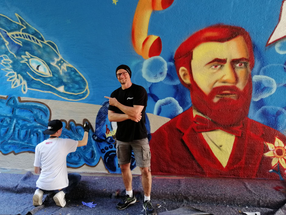 Andreas Arnold vor dem Graffiti seines Drachen Fionrir, mir dem er in der Friedberger Fußgängerunterführung „Zum Kühlen Grund“ im Rahmen eines Jugendprojekts im Jahr 2019 geehrt wurde.