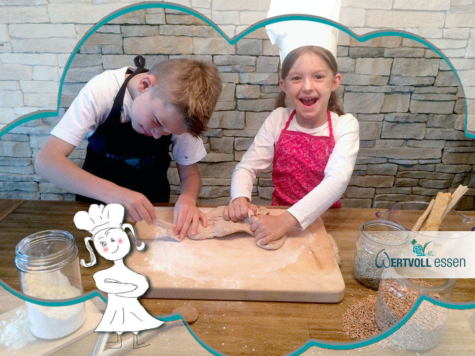 2 Kinder arbeiten mit einem Brotteig vor einer Steinwand und haben Spaß beim Backen lernen