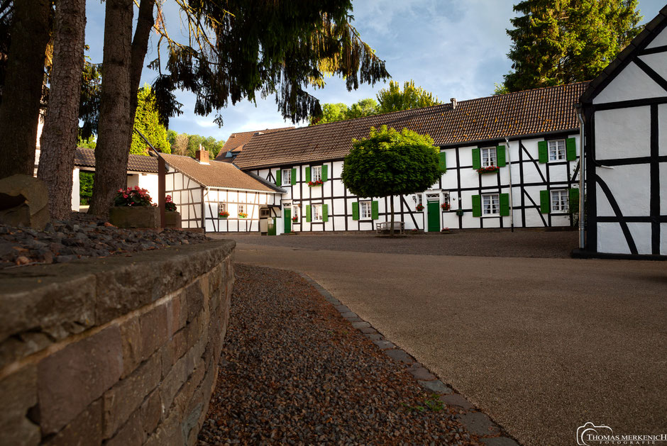 Wirtschaftshof der Burg Zweiffel in Herrenstrunden, im Hintergrund das Herkenrather Tor