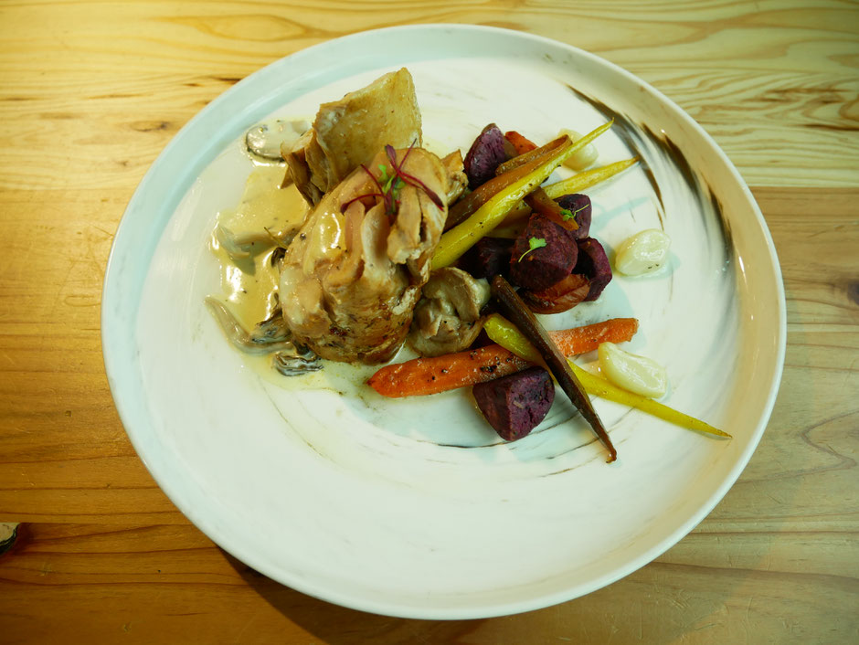  Pan-Seared Lacto Chicken Roulade with a side of sweet potatoes and carrots served on a white plate on wooden table from Mahota Pantry