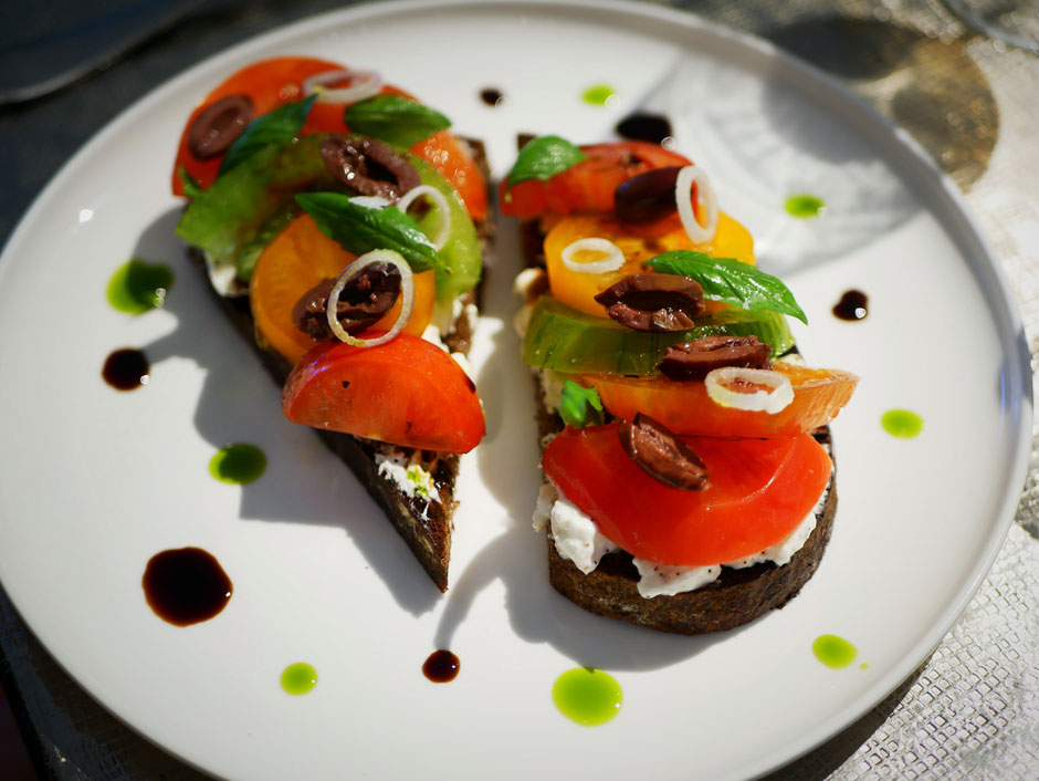 Heirloom tomatoes, burrata, olives and basil served on bread at Como Cuisine Singapore