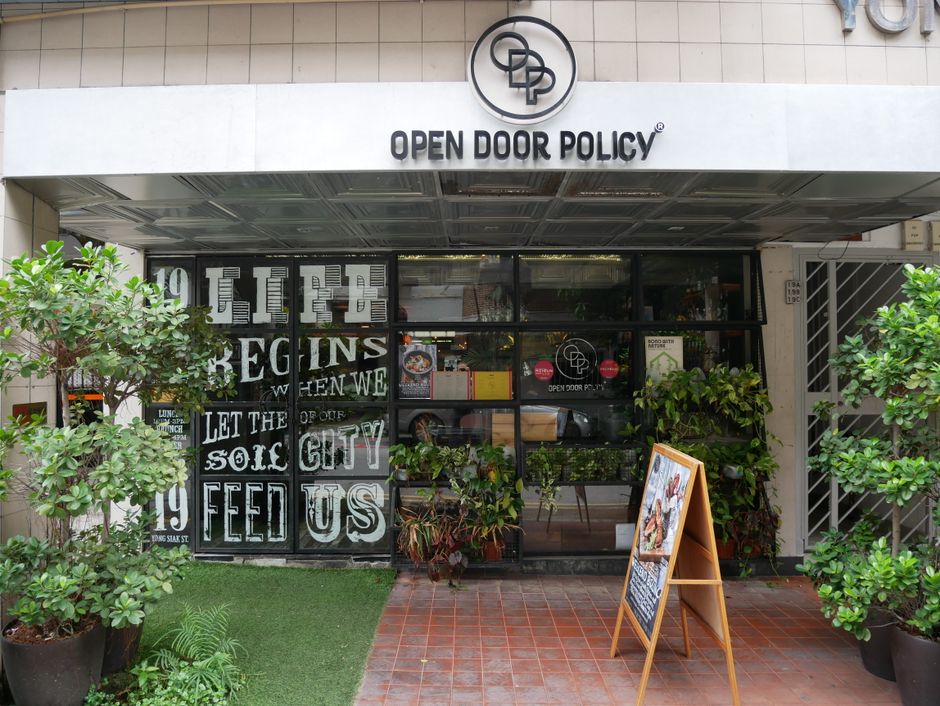 The entrance of Open Door Policy along Yong Siak street is filled with plants and graphic work