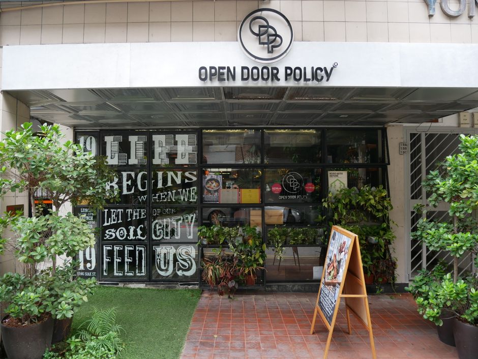 The entrance of  Open Door Policy along Yong Siak street is filled with plants and graphic work