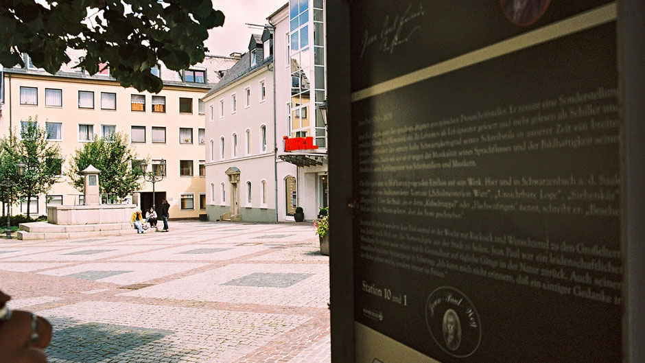 Hinten der Jean-Paul-Brunnen auf dem Schlossplatz in Hof, vorne Stationstafel 10 und 1