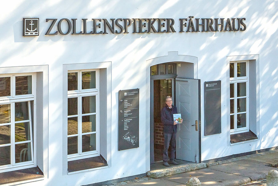 Autor Joachim Mohr am Eingang des Zollenspieker Fährhauses, mit dem Buch "Das Zollenspieker Fährhaus"