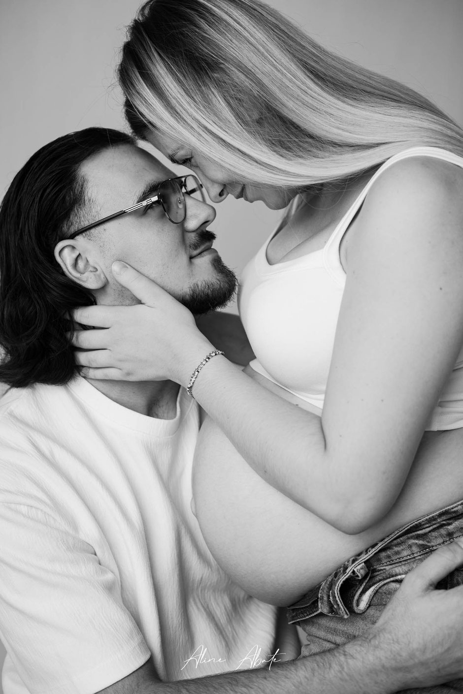 Photo grossesse en couple en studio, tendre moment noir et blanc