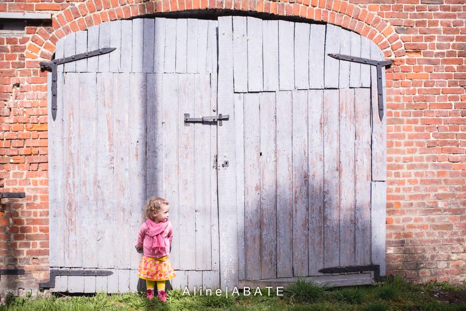 enfant adossé à une porte de garage bleue