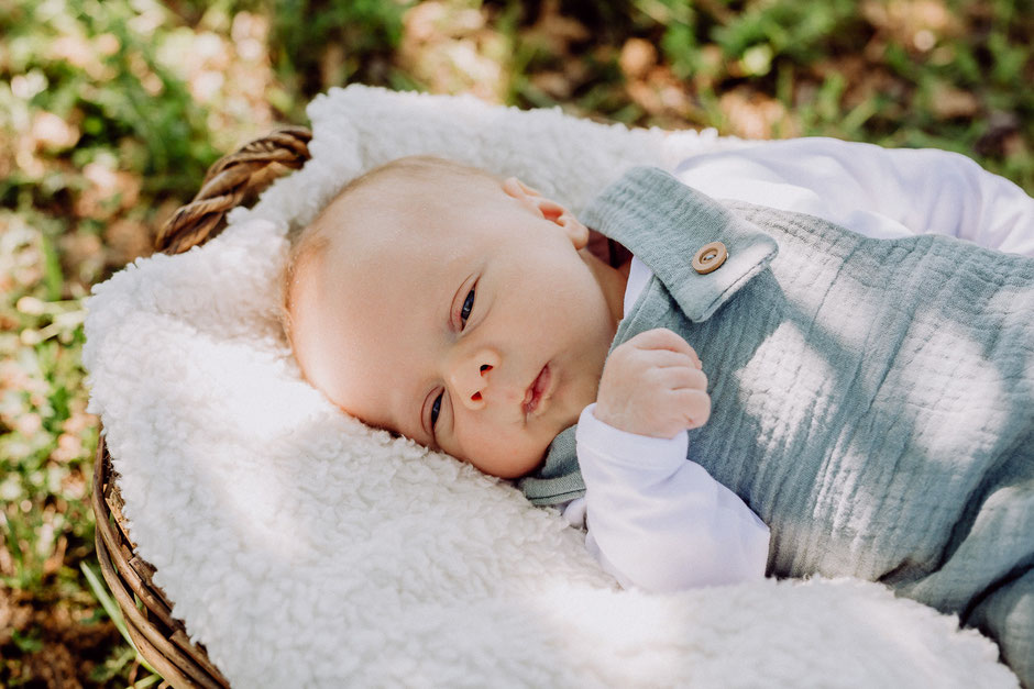 Säugling liegt mit geöffneten Augen im Korb bei Fotoshooting in Bodenheim