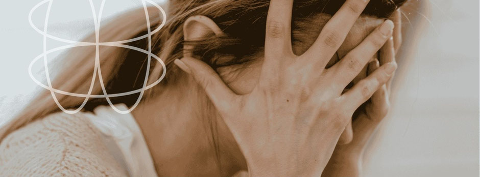 Bild von trauriger Frau, Frau hält sich den Kopf in den Händen – Ausdruck von innerer Überforderung, Selbstzweifeln und dem Wunsch nach Orientierung und Verbindung zu sich selbst