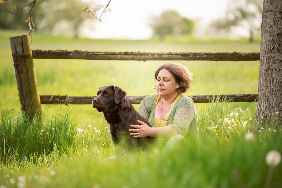 Rebecca Handwerk in stiller Verbundenheit mit ihrem Hund auf der Wiese, ganzheitliche Begleitung im Seniorhund Kompass