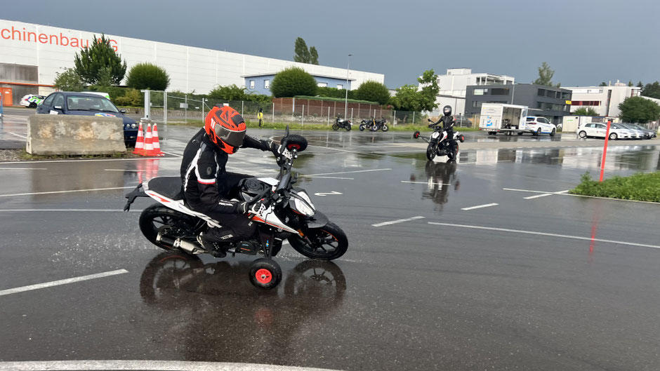 KTM Duke 390 mit Stützrädern und grosser Schräglage auf sehr nasser Strasse