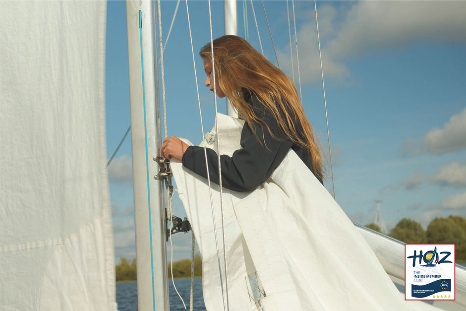 Junge Frau beim Segelsetzen auf dem Meer – praxisnahe Segelausbildung für Hochseeschein Schweiz