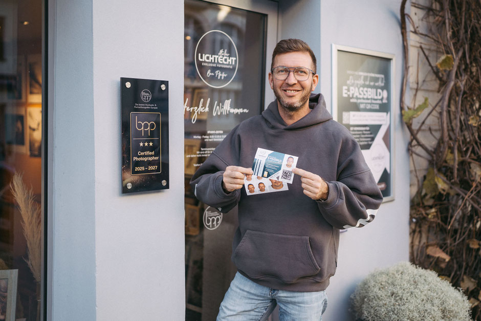 Ben Pfeifer (ausgezeichneter fotograf) zeigt einen qr-code und Passbilder in die kamera, lichtecht, fotograf annaberg passbilder, fotostudio lichtecht