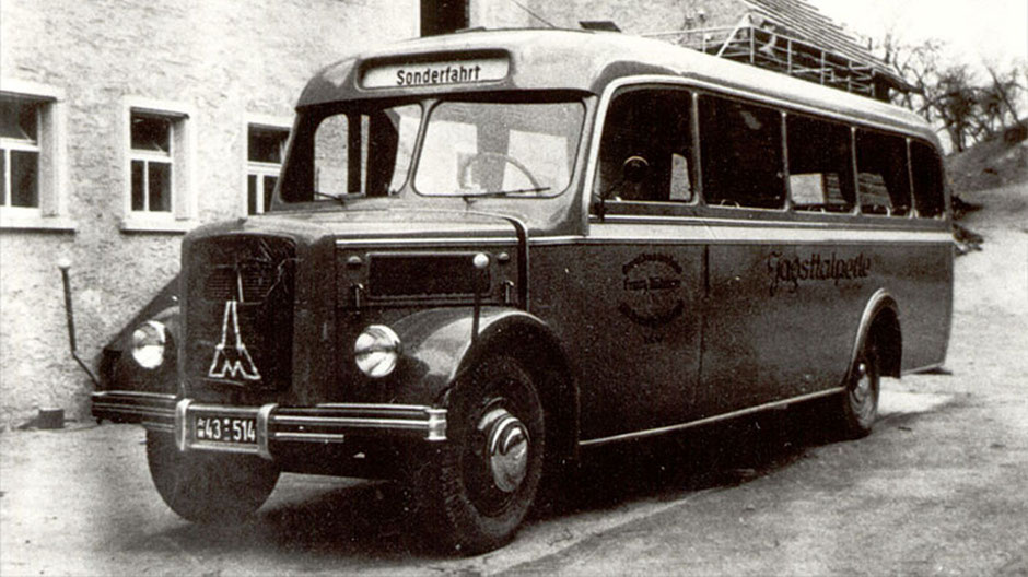 On a black and white picture you can see a coach from the 50s. It is a Magirus Deutz. Nobody is sitting at the wheel, above you can see the notice "Sonderfahrt", which is special trip.