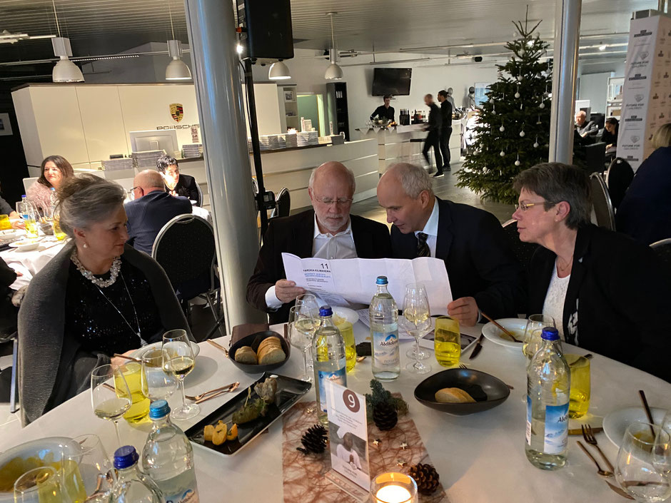 Sigrid und Tilman Ott mit Bernhard und Elke Forster beim Studieren der Krankenhauspläne während der Porsche Spendengala.