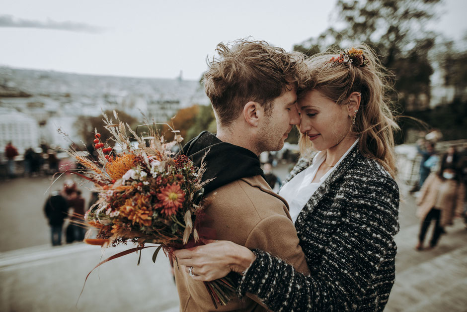 Bridal couple in Paris in Montmartre with a bridal bouquet