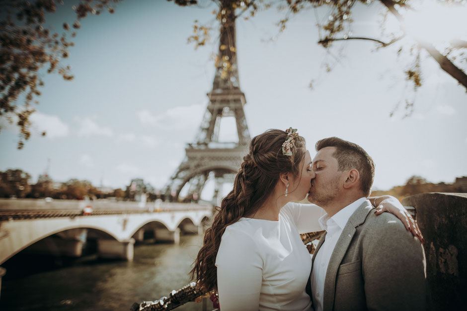 Brautpaar küsst sich vor dem Eiffelturm in Paris 