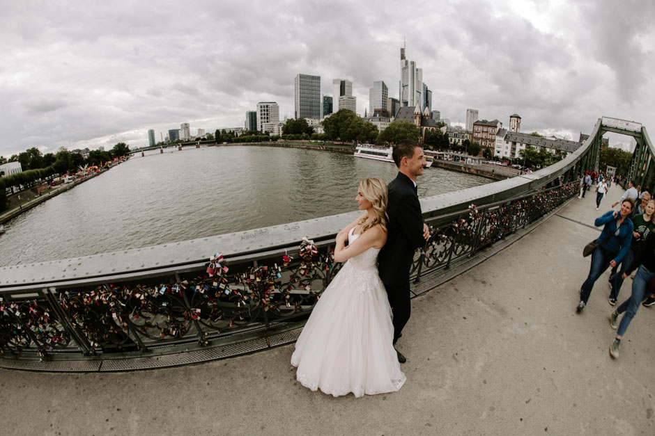 Brautpaar steht Rücken an Rücken auf dem Eisernen Steg in Frankfurt - Hochzeitsfotograf Frankfurt
