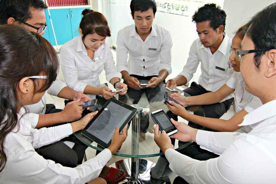 De jeunes Cambodgiens lisant la Bible sur leur smartphones et tablette