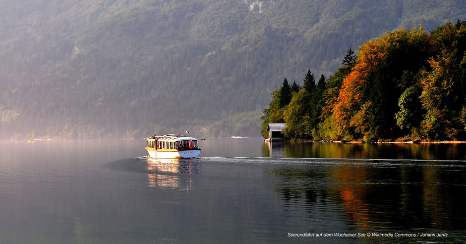 See im Triglav Nationalpark, Schiff fährt auf dem See, Boot fährt auf dem See, Herbststimmung am See, Wocheiner See, Bootsfahrt, kontrastreiches Bild See