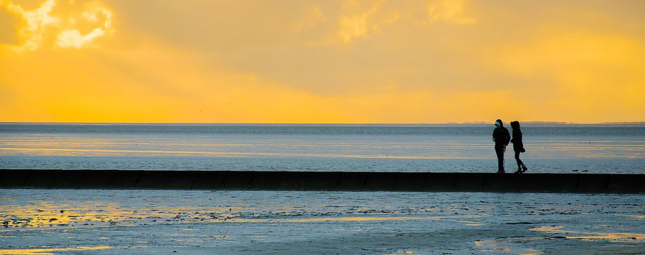 zwei Menschen laufen am Strand land - Sonnenaufgang auf Usedom
