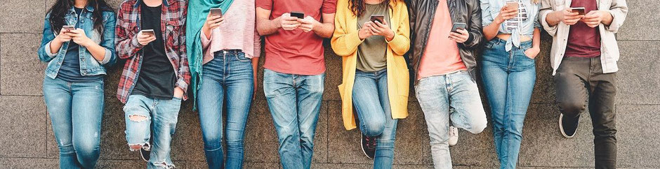 Klassenreise-Versicherung der TravelSecure – Schülergruppe mit Handy auf Klassenfahrt