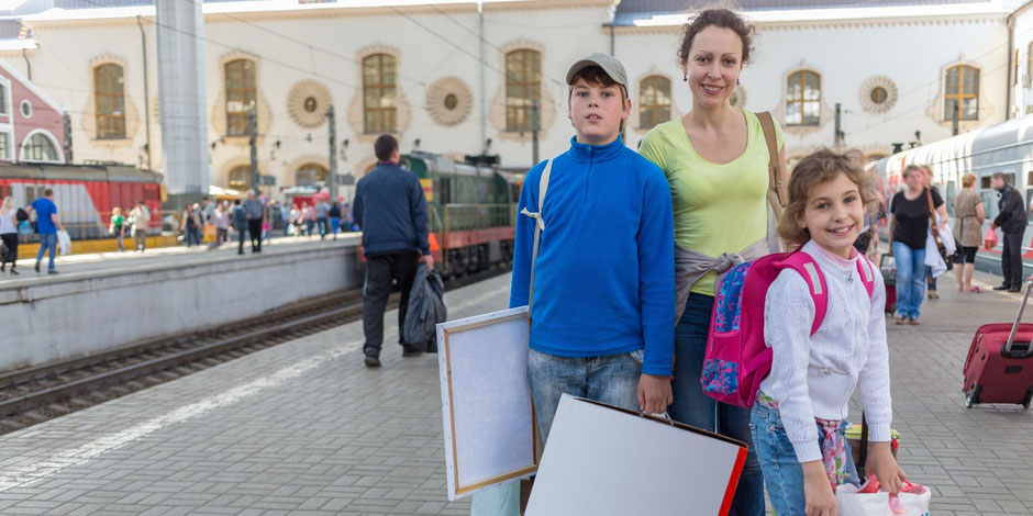 Mutter begrüßt ihre Kinder nach einer Reise – mit gutem Gefühl dank ERGO Reiseschutz.