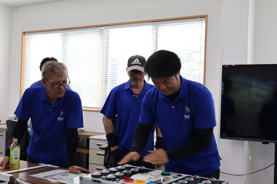 同僚が見つめる中、反応テストをする社員