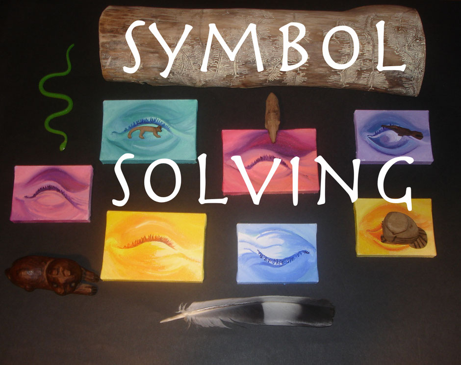 Symbol-Solving-Angebots-Bild mit bemalten Leinwänden, kleinen Figuren, Holzobjekten und einer Feder auf schwarzem Hintergrund. Schriftzug SYMBOL SOLVING im Bild.