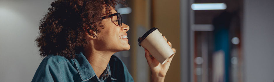 Frau mit Brille trinkt Kaffe