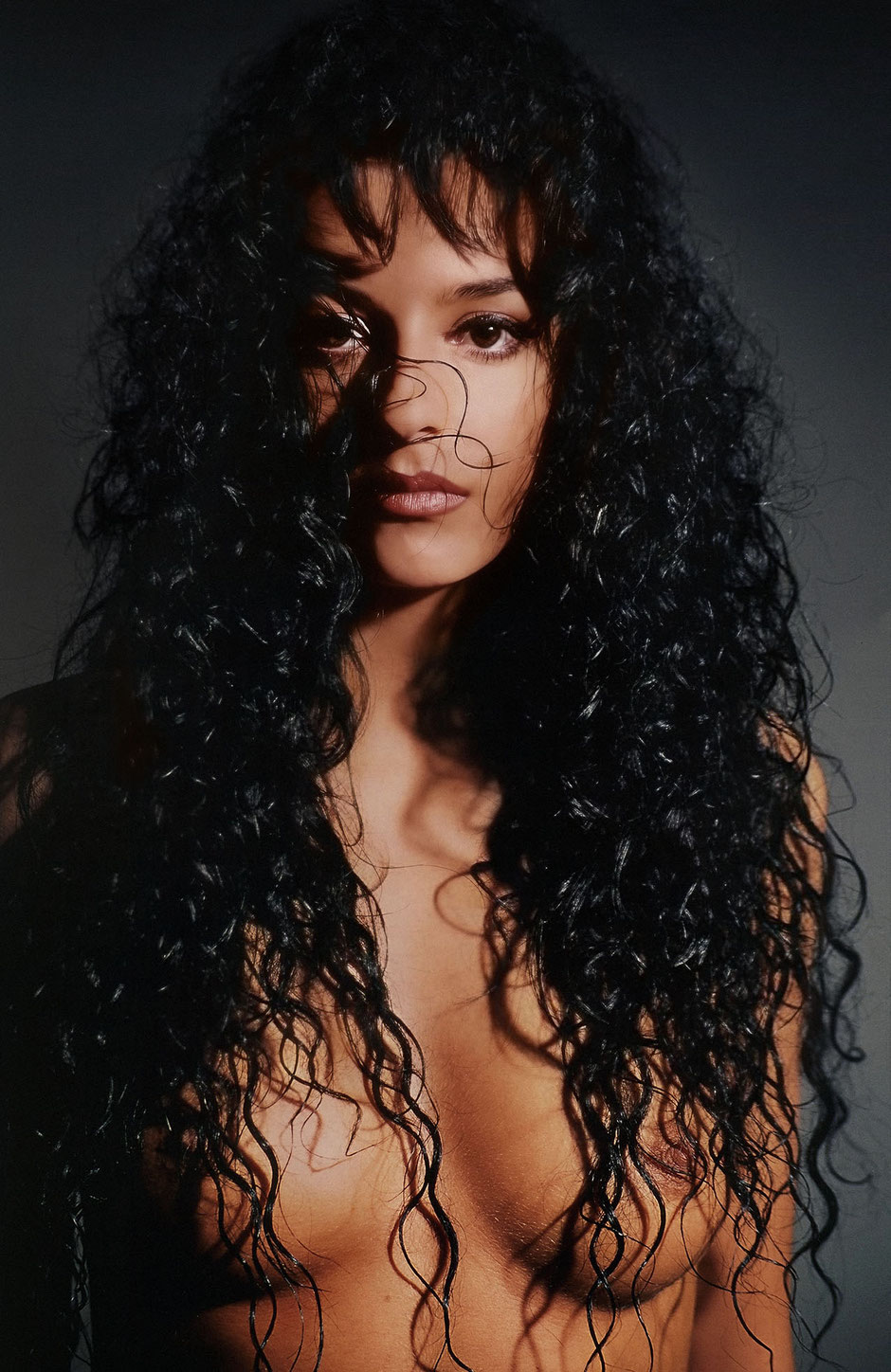 Erotic portrait of nude Gabriela staging her curly black hair