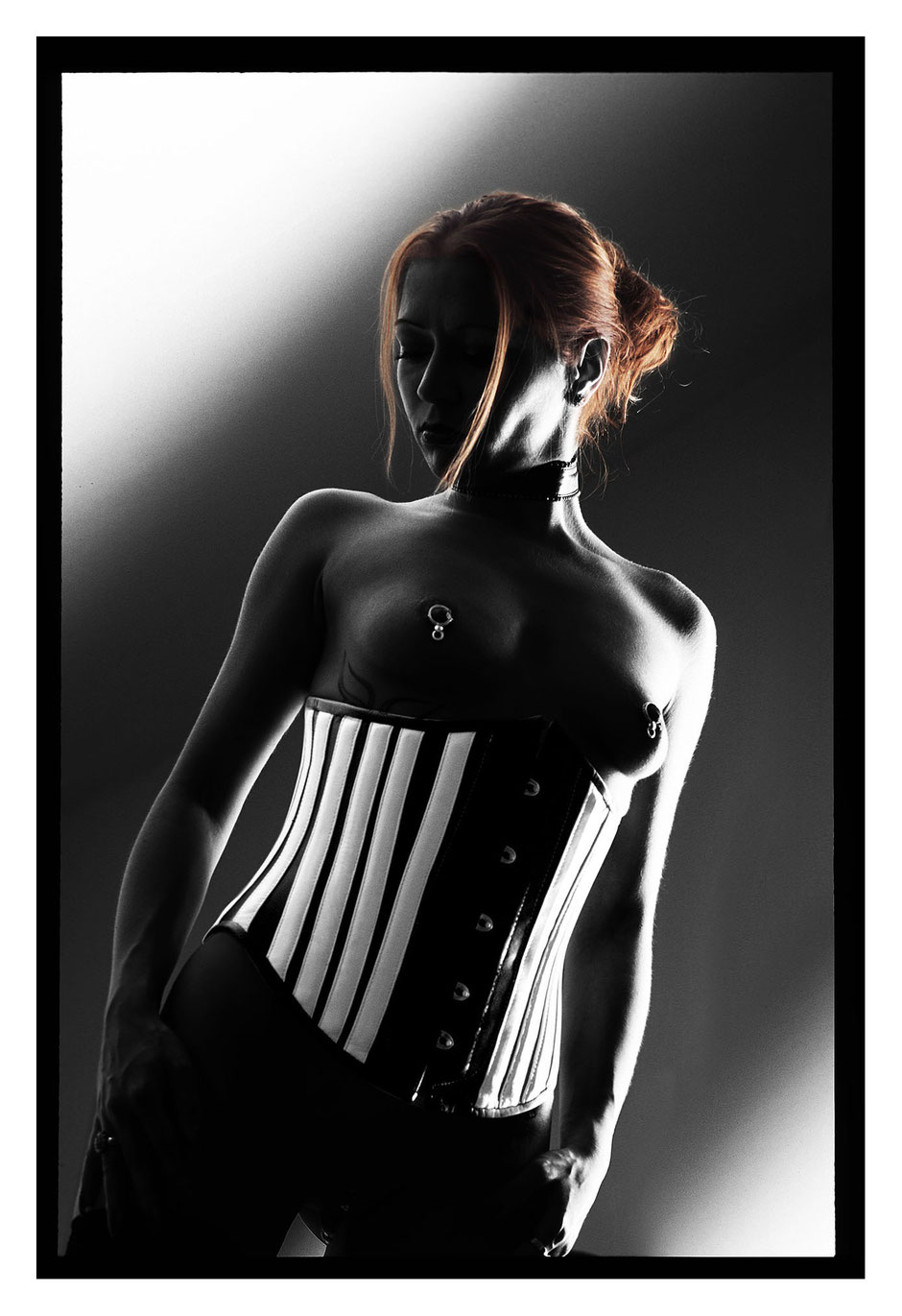 Fetish model Sammy wearing a corsett and shows her pierced nipples