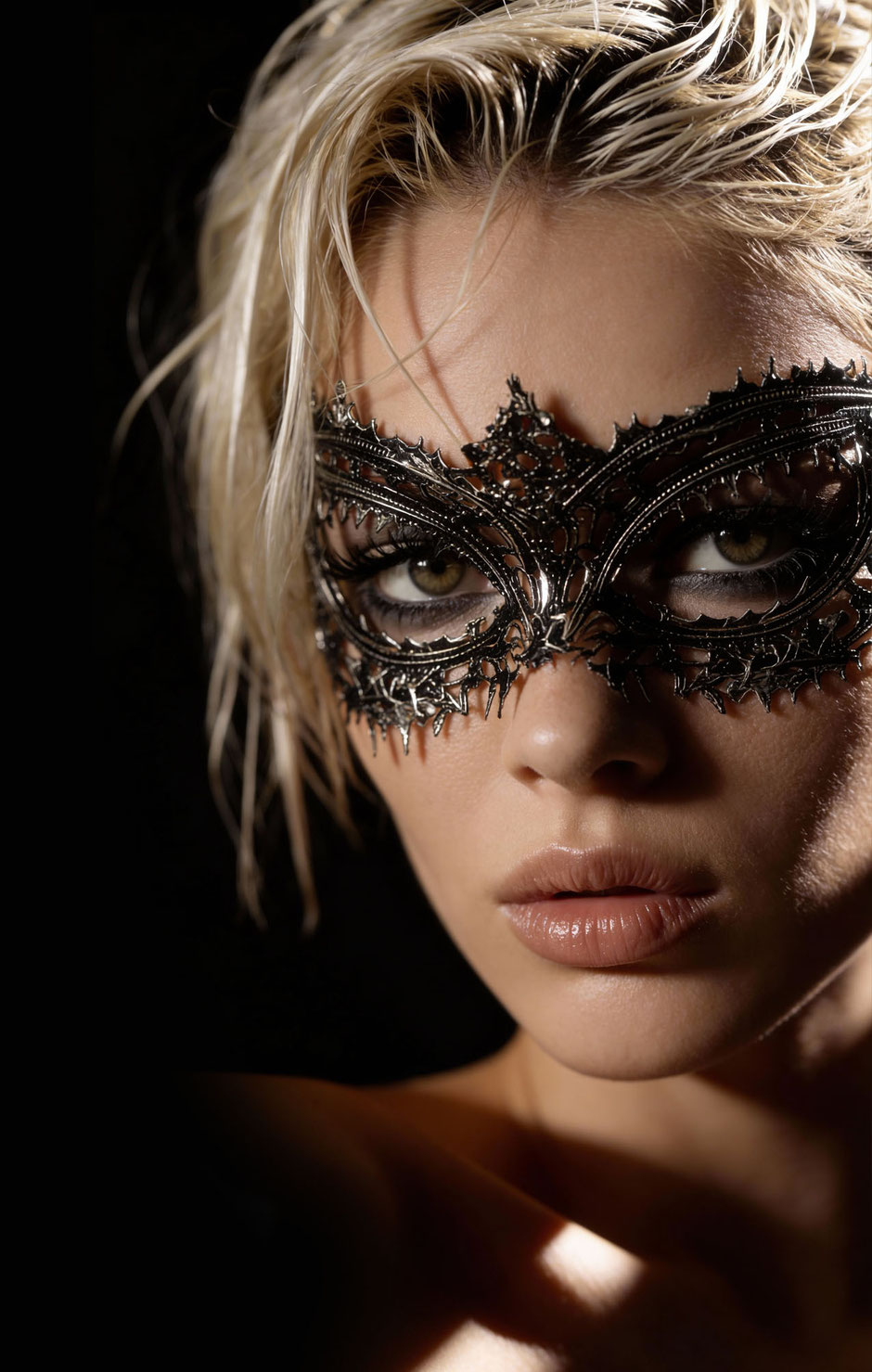 portrait photo of a blonde woman wearing a Venetian silver mask