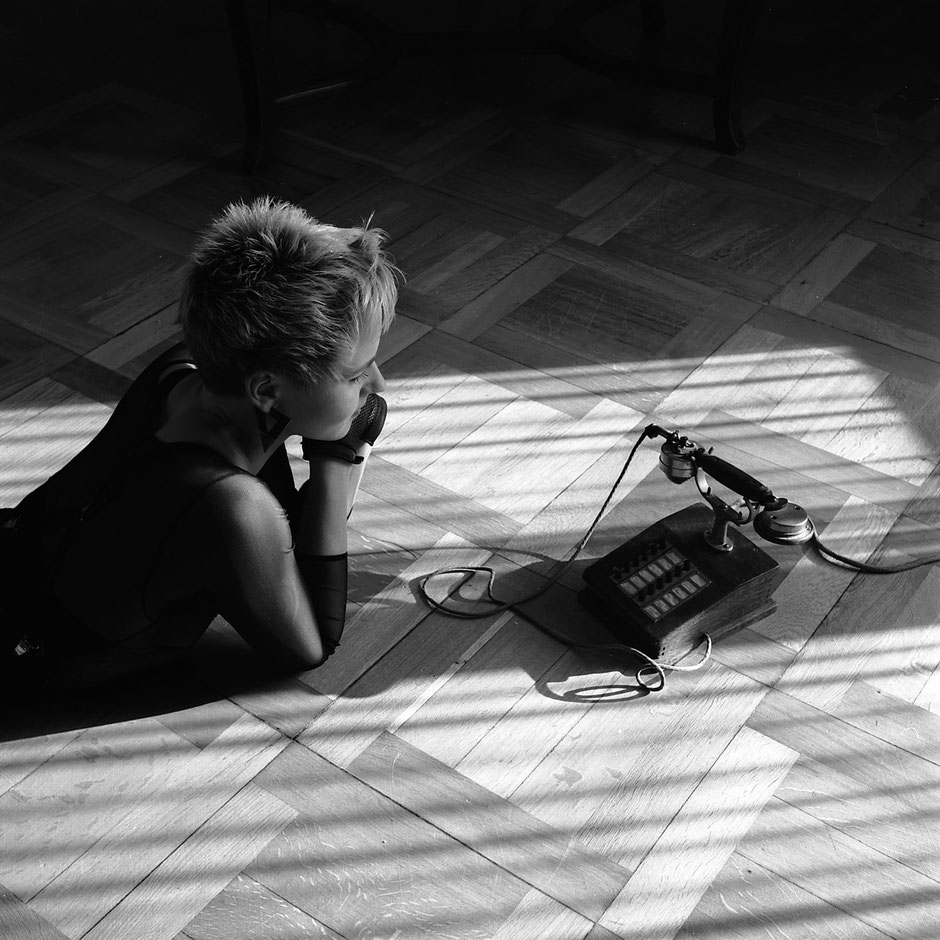 Portraitaufnahme von Model Ulla liegend mit historischem Telefon by Martin Boelt Portrait Photography