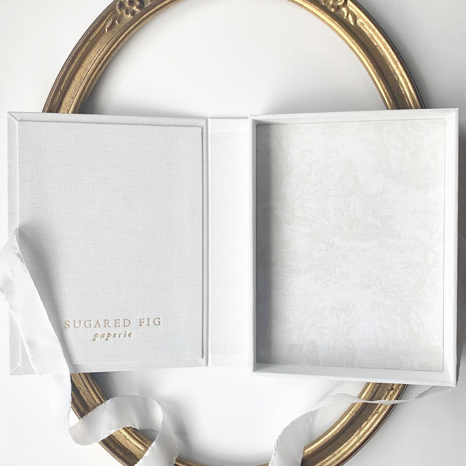 Box with a drop spine for wedding invitations, lined with seychelle velvet, closed with a silk ribbon and foil pressed logo